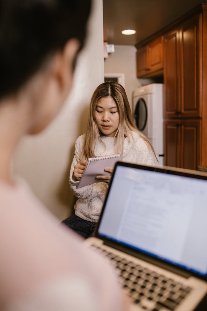 about-02 Young woman engaged in online learning at home with a laptop and notebook.